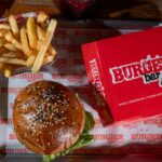Burger rouge et noir aux couleurs de Squid Game posé sur plateau fast-food