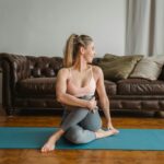 jeune femme allongée sur un tapis de yoga soulagée de ses crampes menstruelles