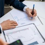 Banquier en costard analyse des chiffres devant graphique de solvabilité