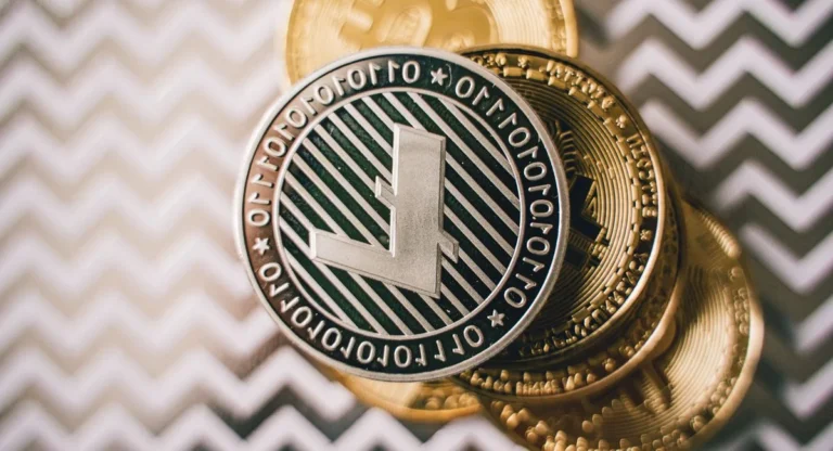 Deux mains tiennent des pièces de crypto sur fond d'écran de trading