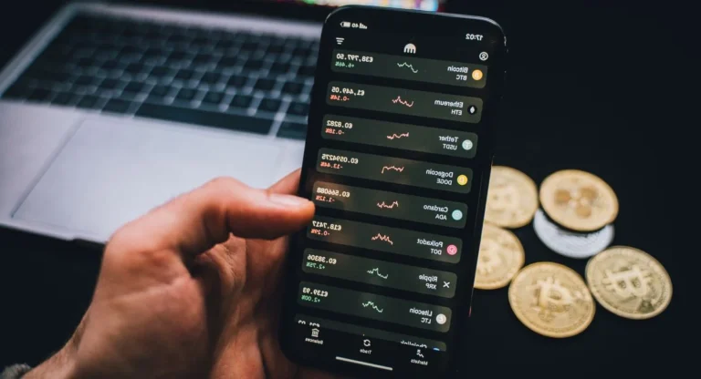 Mains manipulant des jetons numériques devant un écran réseau blockchain