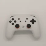 Manette Nintendo Switch posée sur un canapé avec jeux vidéo