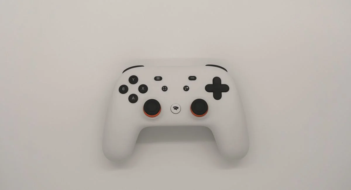 Manette Nintendo Switch posée sur un canapé avec jeux vidéo