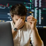 Personne sur écran avec interface Binance affichée, ambiance trading concentrée