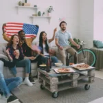 Salle de séjour, écran TV lumineux, jeunes concentrés sur un site de streaming illégal