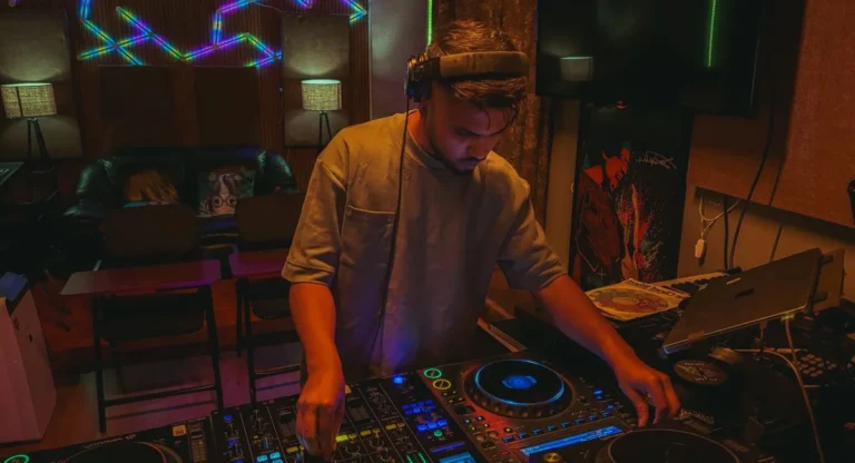 Un chanteur électro devant son laptop, reflets néons, ambiance studio urbain