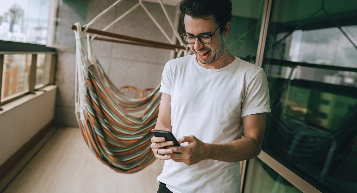 Un jeune homme consulte son wallet crypto sur smartphone dans un café moderne