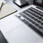 Un rédacteur concentré devant son écran, clavier et carnet à la main