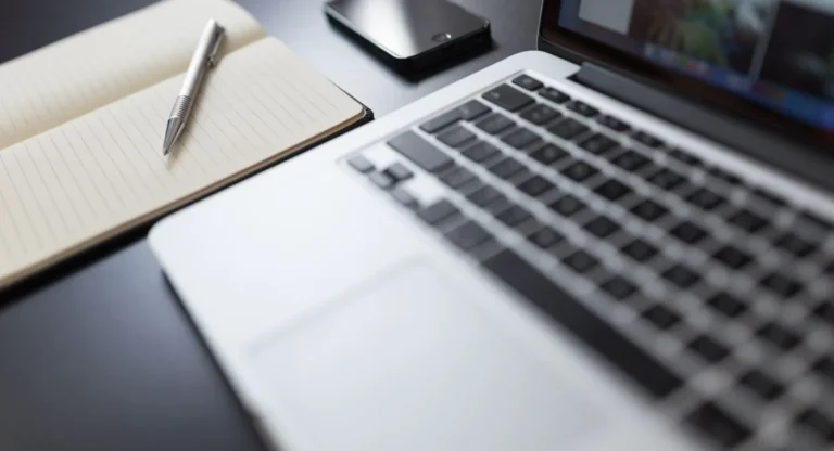 Un rédacteur concentré devant son écran, clavier et carnet à la main