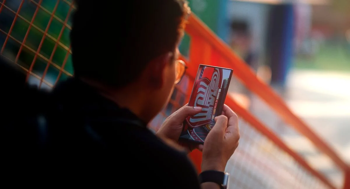 Utilisateur tenant un smartphone affichant des objets virtuels en 3D superposés à un bureau réel