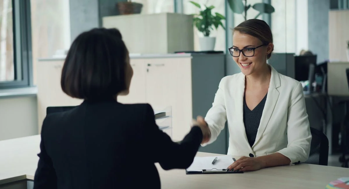 Un business developer digital en pleine négociation salariale tend un contrat